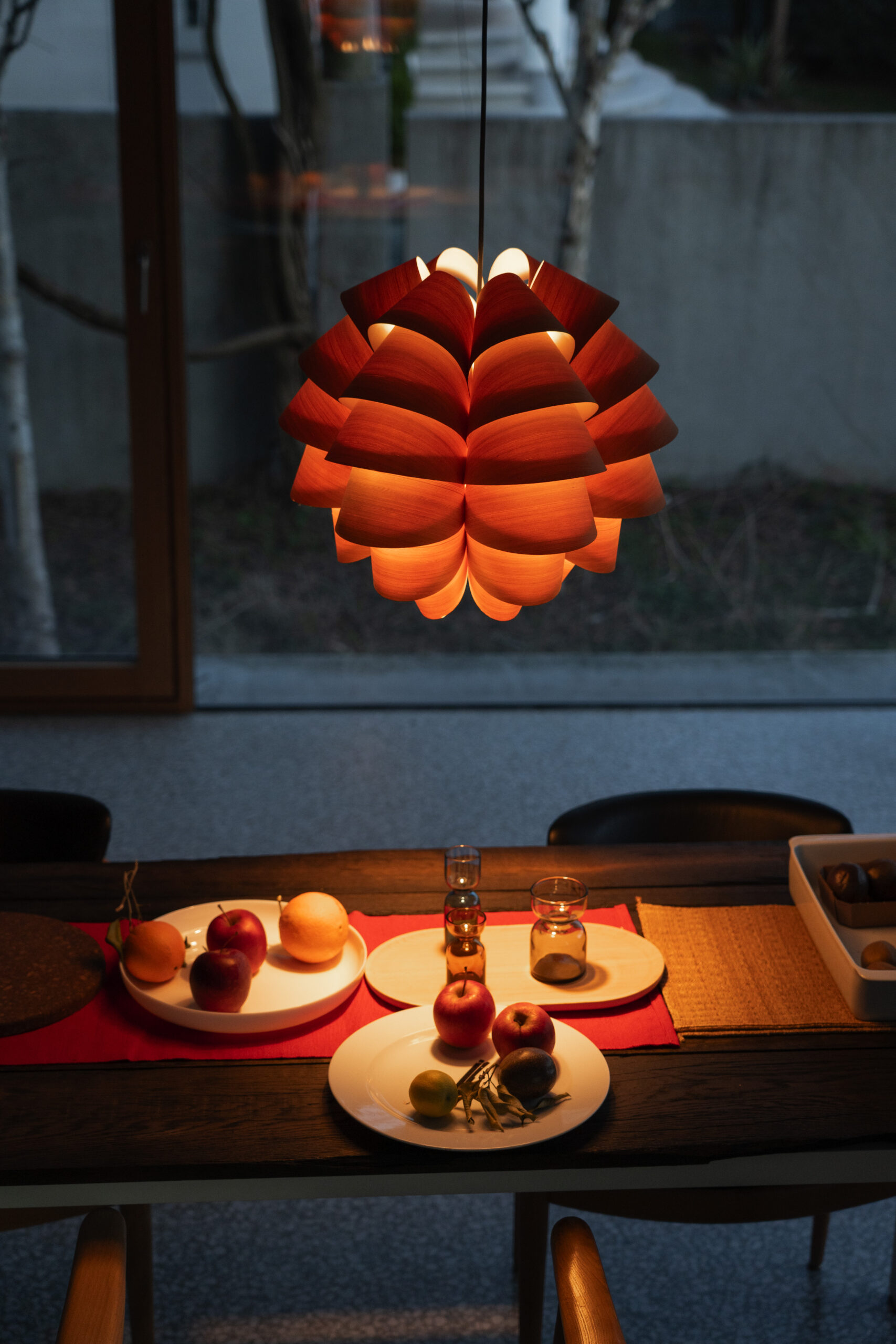 Sence Furu M6 larch veneer pendant lamp above a dining table with warm light at dusk